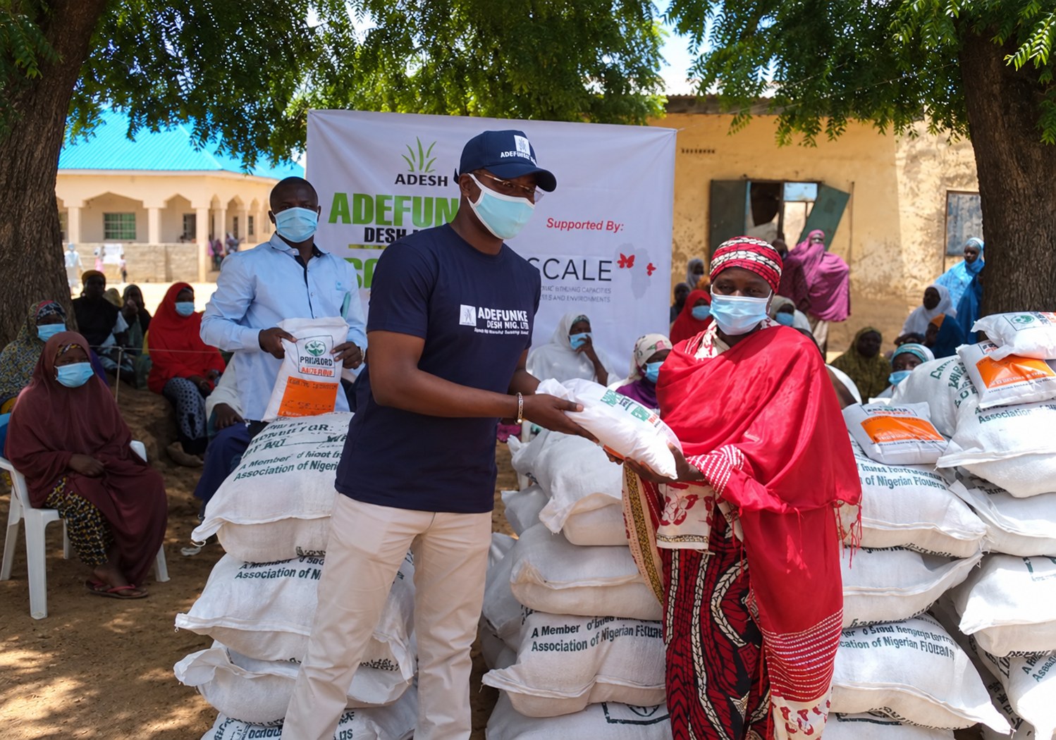 Adefunke Desh, supported by 2SCALE, distributing seed and food support to a women farmers group